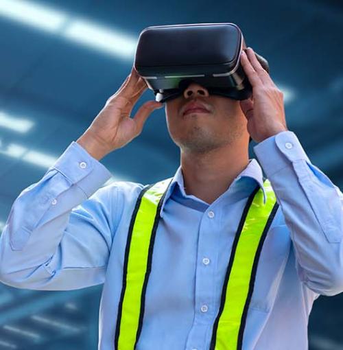 man met VR-bril in industriehal met robot op de achtergrond