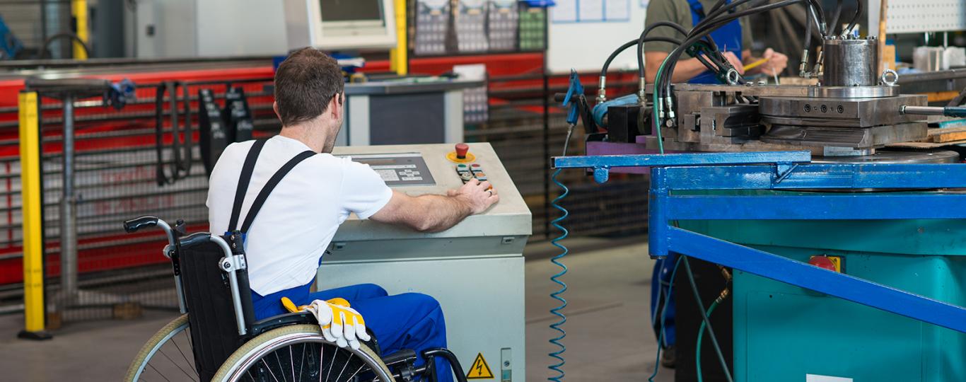 Man in rolstoel werkt aan machine