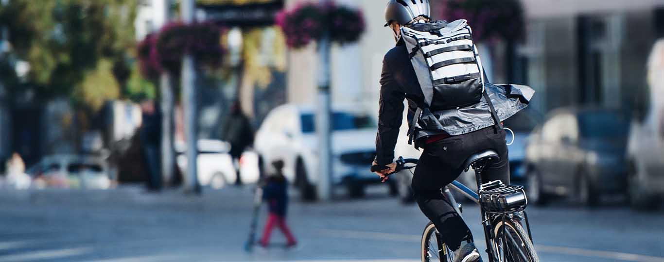 duurzame mobiliteit: man op elektrische fiets op weg naar het werk 