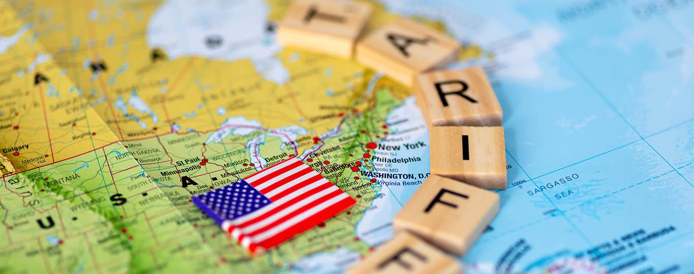 wereldkaart daarop vlag van VS en letterblokjes tariffs