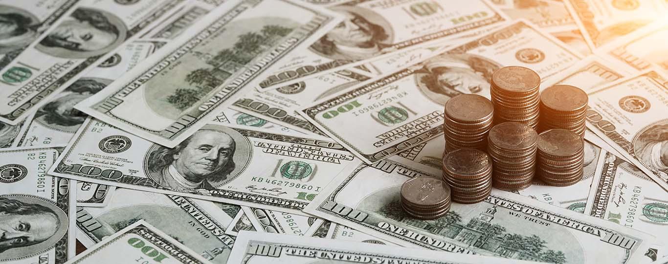 dollarbiljetten en munten met een flauwe lichtschijn op de achtergrond