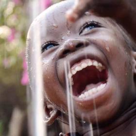 Afrikaanse jongen is blij met water