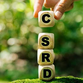 hand stapelt blokjes met letters CSRD op elkaar