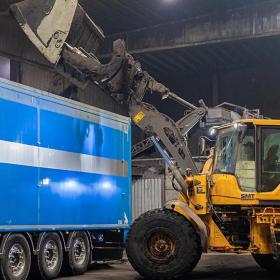 graafmachine kapt organisch afval in vrachtwagen