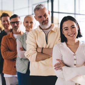teamleden met diverse achtergrond staan  lachend op een rij