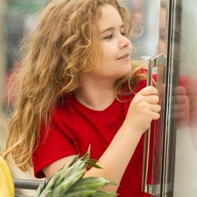 meisje neemt iets uit een frigo in een supermarkt