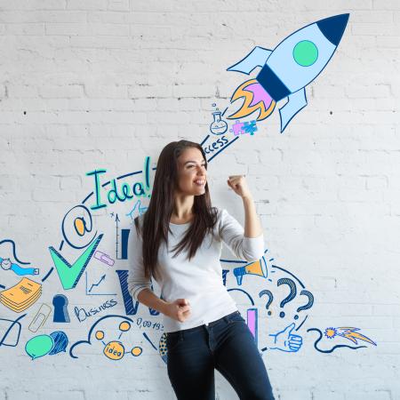 lachende vrouw maakt vuist voor een muur met illustraties die staan voor creatief ondernemerschap