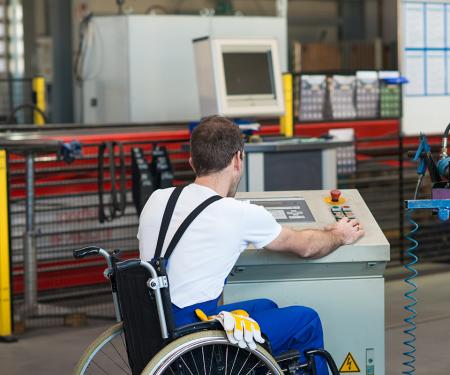 Man in rolstoel werkt aan machine
