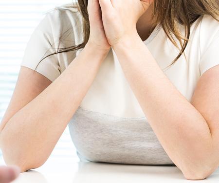 Vrouw houdt handen voor haar mond na slecht nieuws