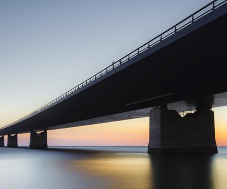 Brug over water bij avondlucht