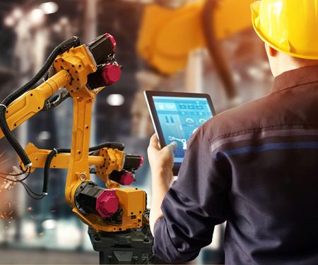 Ingenieur controleert via tablet werk van robotarmen