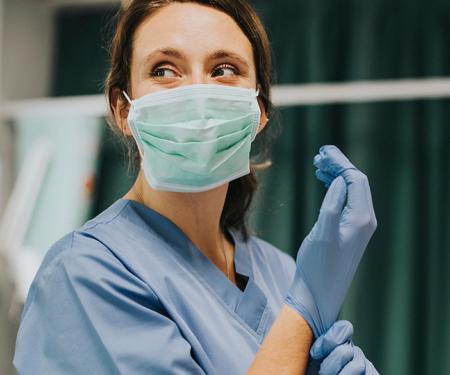 Verpleegkundige trekt handschoenen aan