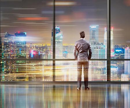 Zakenman kijkt uit raam naar futuristische wereld