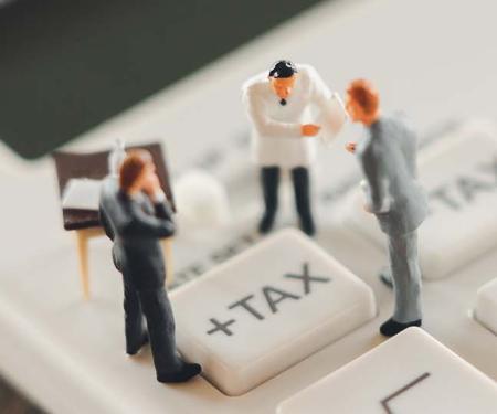 belastinghervorming: miniatuurmensen in discussie rond taxknop op rekenmachine