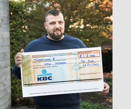 Nick De Ridder met een cheque voor vzw Rebron