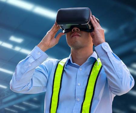 man met VR-bril in industriehal met robot op de achtergrond