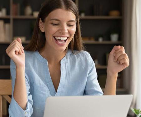 Werkneemster juicht bij het lezen van een e-mailbericht