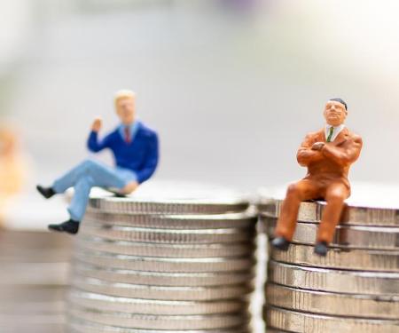 illustratie 2 miniatuurpoppetjes zitten elk op een stapeltje geld, eentje houdt de armen gekruist