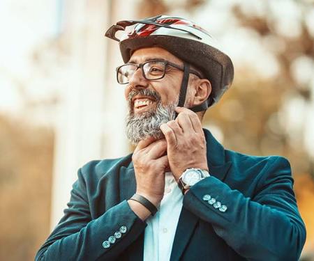 man met vest zet fietshelm op