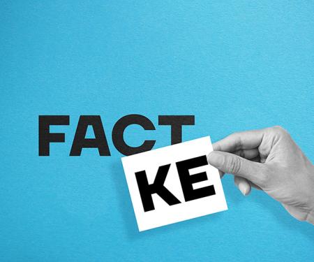 hand legt een kaartje en maakt hierdoor van het woordje fact fake