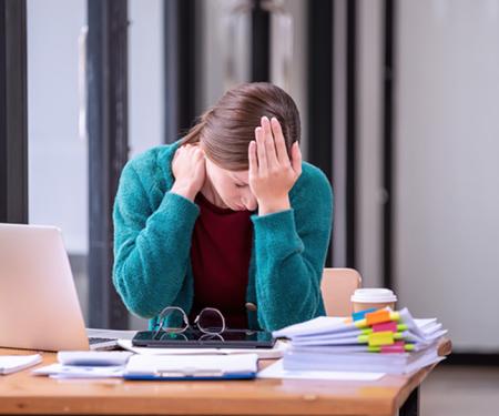 werkneemster met hoofdpijn aan een bureau