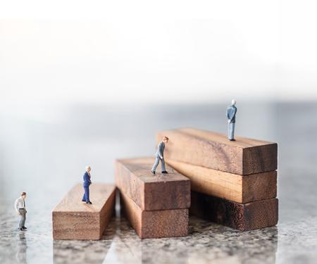 miniatuurpoppeltjes op stijgende stapels houten blokken