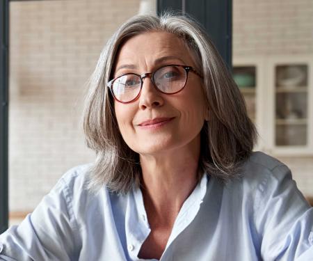 Oudere vrouw met laptop aan bureau