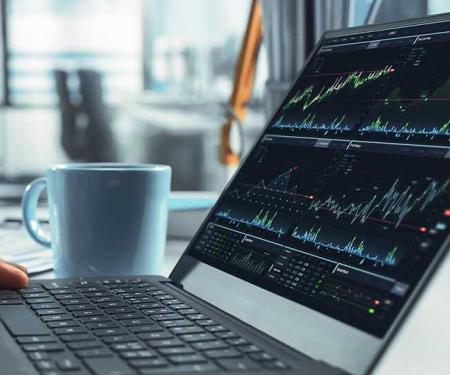 man checkt op laptop notering van aandelen