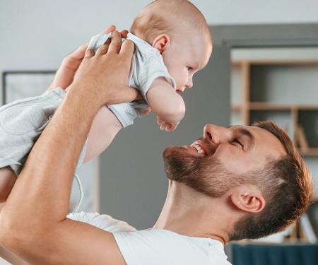 blije vader houdt baby omhoog