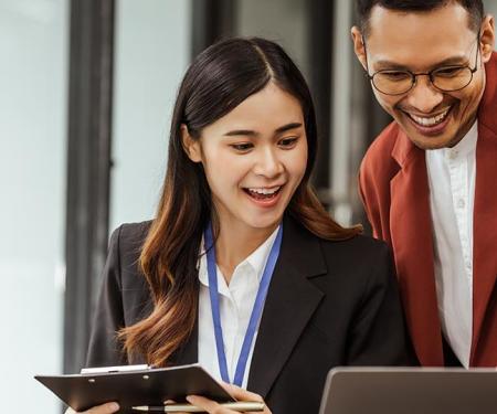 twee collega's kijken samen naar een beeldscherm