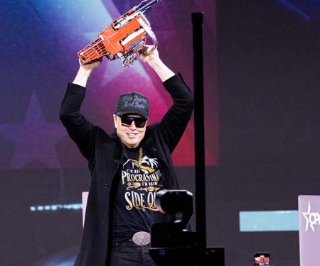 Elon Musk al zwaaiend met kettingzaag