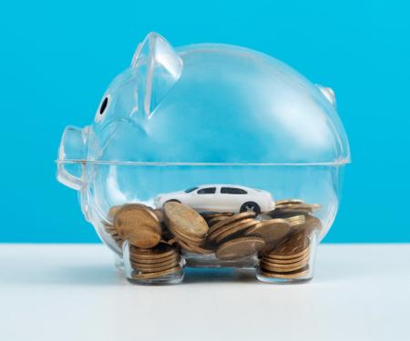doorzichtig spaarvarken met geld en auto