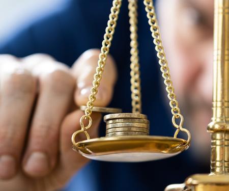 man weegt geldstukken af op weegschaal