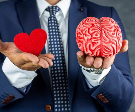 zakenman houdt brein en hart in zijn handen