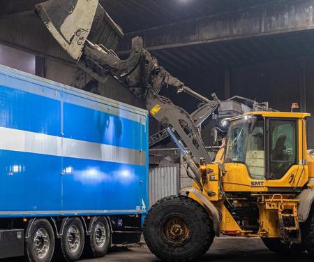 graafmachine kapt organisch afval in vrachtwagen